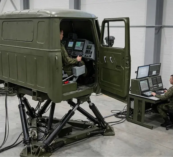 Військовослужбовець у кабіні динамічного тренажера вантажного автомобіля на шестиосьовій рухомій платформі, поруч інструктор за пультом управління симуляцією