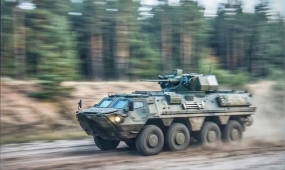 Бронетранспортер у русі на високій швидкості під час військових навчань на полігоні