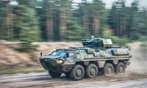 Бронетранспортер у русі на високій швидкості під час військових навчань на полігоні